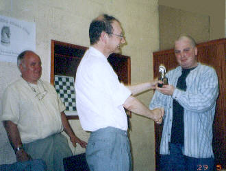 Stuart Barber (right) receives the knight trophy for his win in the Winter 15-minute Tournament from President Ray Collett (centre). Club Secretary Jim Keene (left) looks on